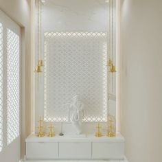 a white and gold bathroom with two golden faucets