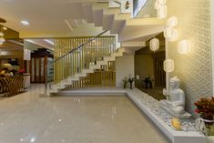 the interior of a modern house with stairs and buddha statue on display in the center