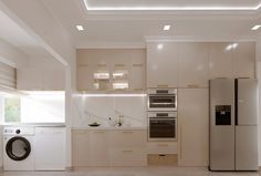 a modern kitchen with beige cabinets and white counter tops, including a washer and dryer