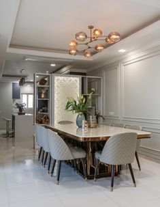 a dining room table with four chairs and a vase on the center island in front of it